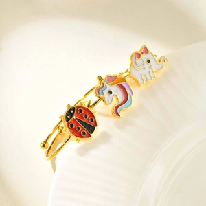 Close-up of gold stainless steel child ring with unicorn and elephant charms