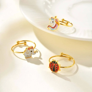 Detailed view of adjustable gold-finish unicorn, elephant, and ladybug rings for kids