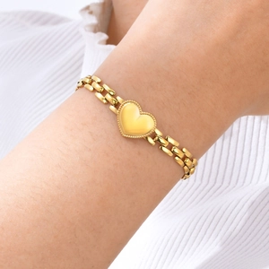 Close-up of golden heart-shaped pendant with beaded edges on a flat link chain