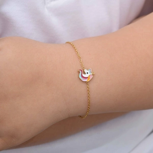 Detail of a child's gold unicorn bracelet with colorful enamel on a delicate chain