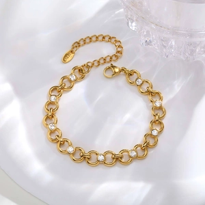 Detailed macro view of a gold-tone stainless steel bracelet with white zircon stones
