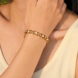 Close-up of a gold-plated link bracelet with white zircon stones on a female wrist