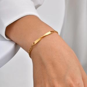 Gold-plated stainless steel Figaro Mobius chain bracelet shown on a female wrist