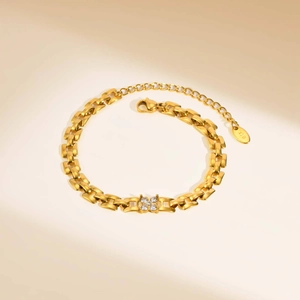Close-up of 18K gold chain bracelet with clover zircon charm and adjustable lobster clasp