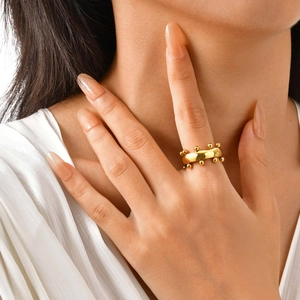 Anillo de banda con cuentas doradas pulidas en modelo con diseño minimalista