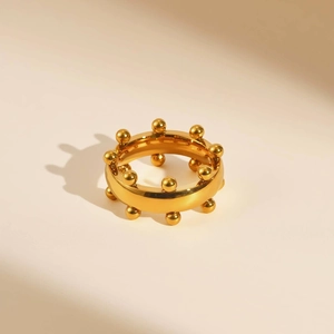 Detalle de anillo corona de acero inoxidable dorado con adornos de cuentas minimalistas