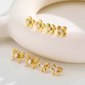Juego de pendientes dorados con formas de flor y mariposa decorados con piedras de circón