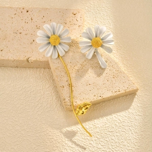 Élégante broche marguerite dorée avec pétales blancs et cœur jaune sur socle de pierre