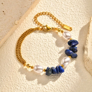 Bracelet doré en acier inoxydable avec lapis-lazuli et perles sur fond de pierre