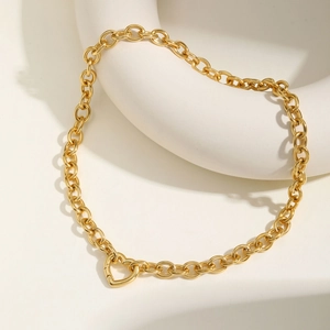Nahaufnahme einer goldenen Gliederkette mit Herz-Knebelverschluss auf weißem Halter