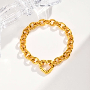 Detailansicht des goldenen Herz-Karabinerverschlusses an dem groben Gliederkettenarmband