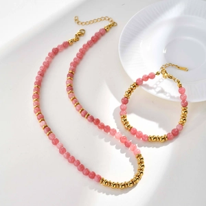 Detail of pink crystal beads and gold stainless steel balls on necklace and bracelet set
