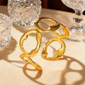 Detail of gold-plated geometric hollow wave ring bracelet with high-polish mirror finish
