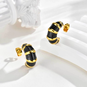 Boucles d'oreilles dorées en forme de C avec émail noir sur support artistique