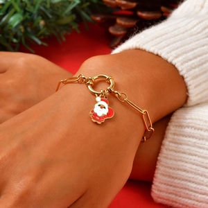 Bracelet à maillons en acier doré avec breloque Père Noël porté au poignet