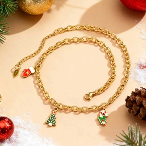 Detail der K18 Goldkette mit Weihnachtsbaum-Anhängern in festlicher Dekoration