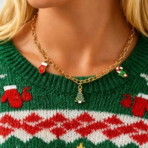 Details einer goldenen Weihnachtskette mit Emaille-Anhängern wie Handschuh und Weihnachtsbaum