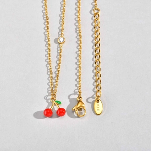 Détail du collier cerise en or 18 carats avec perles rouges, émail vert et zircon