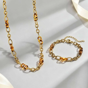 Detail von 18K vergoldetem Schmuckset aus Edelstahl mit Bernstein-Harzringen auf Seide