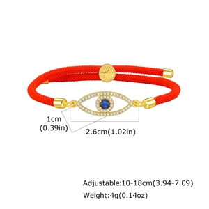 Macro detail of Tree of Life and Evil Eye pendant on adjustable red cord bracelet