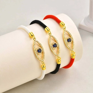 Three evil eye tree of life Milan rope bracelets in black, white, and red with gold accents