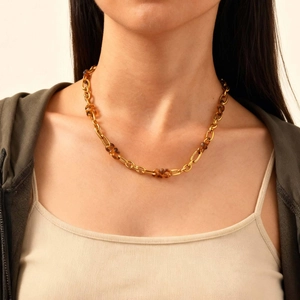 Detail van 18K vergulde roestvrijstalen ketting met schildpadhars kralen gedragen door model