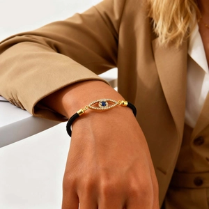 Golden Evil Eye Tree of Life bracelet with black woven cord on model's wrist