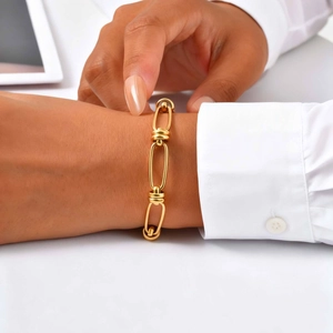 Detail of 18K gold-plated oval link chain bracelet with threaded texture on a wrist