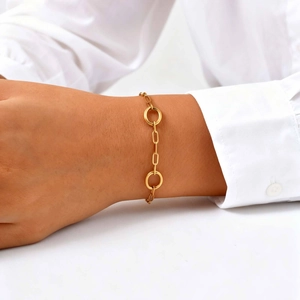 Detailed view of an 18K gold-plated stainless steel oval link chain bracelet on a wrist