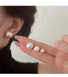 Comparación de cuatro tamaños de elegantes pendientes de perlas blancas en un modelo