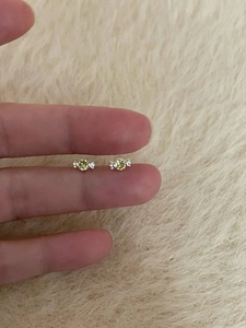 Detail view of mini candy-shaped stud earrings with yellow zircon and silver base