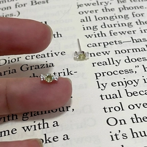 Mini silver candy-shaped earrings with pale yellow zircon shown held by fingers