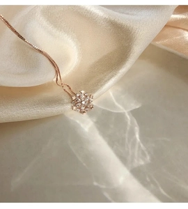 Dettaglio della collana a fiocco di neve in oro rosa con cristalli su seta