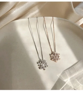 Dettaglio di collane a fiocco di neve in argento e oro rosa con zirconi scintillanti