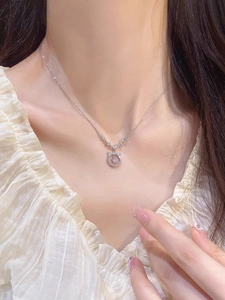 Detail of S925 silver necklace featuring a sparkling pink star pendant on model