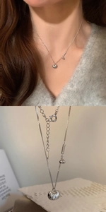 Detail of silver hollow sphere pendant necklace with star patterns and extension chain