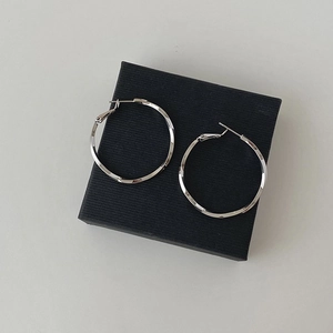 Detalle de pendientes de aro en plata 925 con textura tallada y acabado brillante
