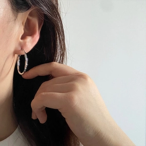 Aros de plata minimalistas para mujer mostrados en una modelo en una vista lateral