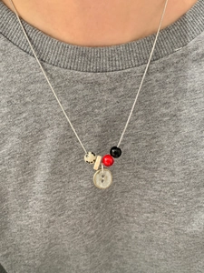 Detail van zilveren slangketting met kleurrijke kralen en vintage knoop hanger