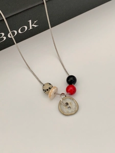 Macro-opname van de zilveren slangenketting met vintage knoop en gestippelde kralen