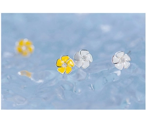Detailed macro shot of yellow and white enamel five-petal flower silver stud earrings