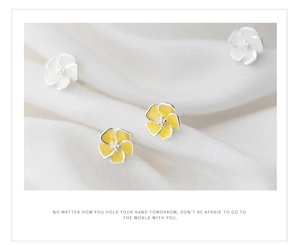 Macro shot of minimalist silver five-petal flower stud earrings with yellow oil drip finish