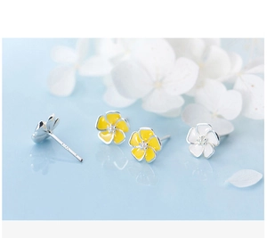 Macro detail of S925 silver floral earrings with yellow and white enamel petals