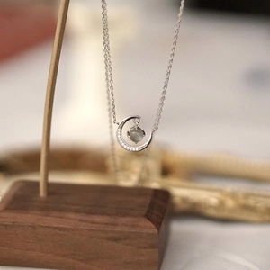 Silver crescent moon necklace with sparkling diamonds and translucent moonstone pendant