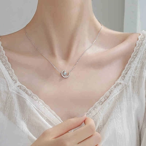 Silver crescent moon necklace with opal stone and crystals on a model neck