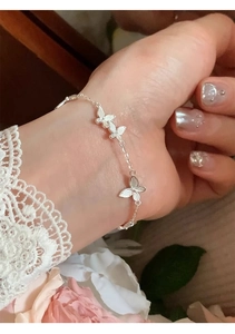 Detailed view of silver butterfly bracelet with delicate wing texture on lace sleeve