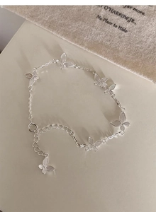 Detailed view of silver butterfly bracelet with five charms and adjustable chain