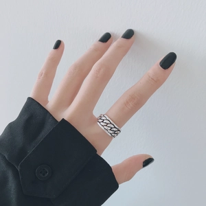 Primer plano de anillo trenzado de plata vintage con acabado oxidado en la mano