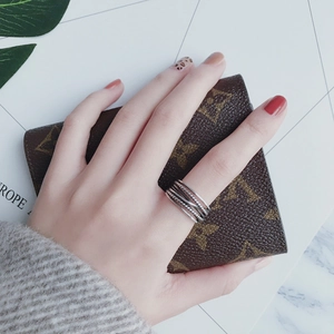 Detalle de un anillo de plata con líneas entrelazadas en la mano de estilo minimalista