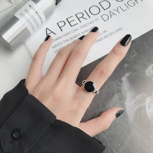 Detalle de anillo abierto de plata con piedra de ágata negra y textura de cadena